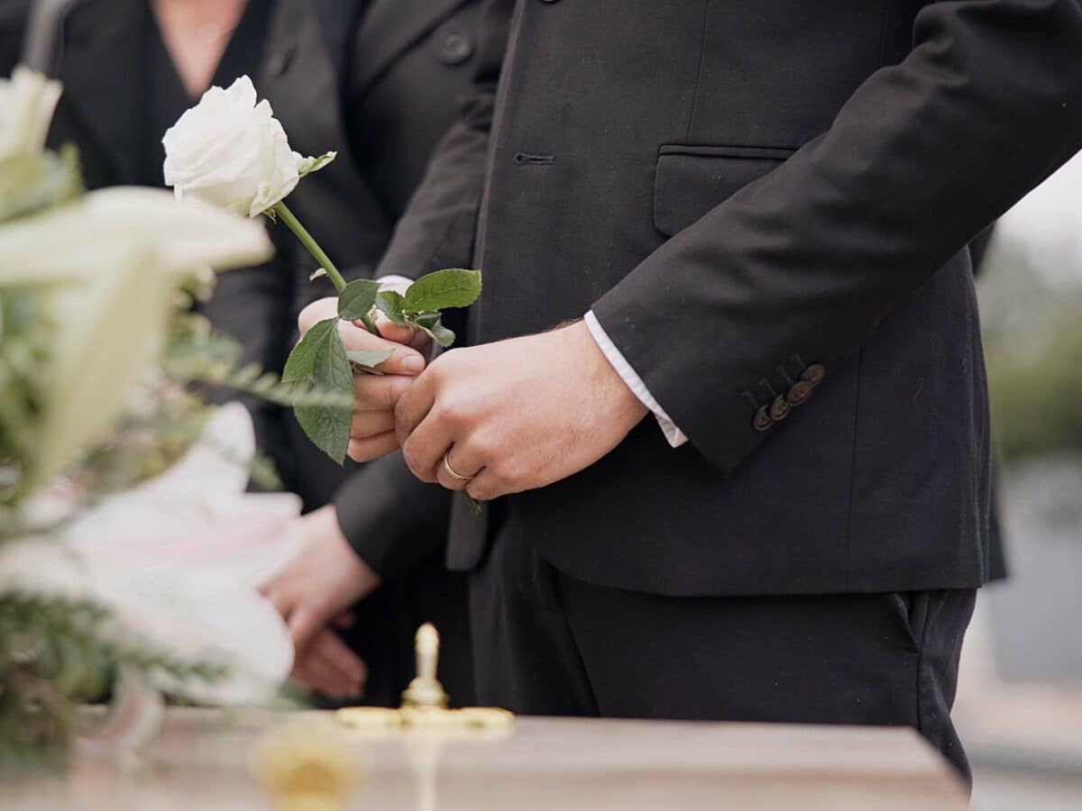 Hand,,Rose,And,A,Person,At,A,Funeral,In,A